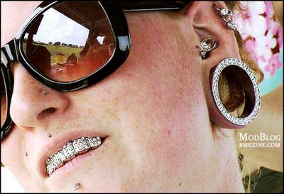Woman with lots of bling on face, grill, etc
